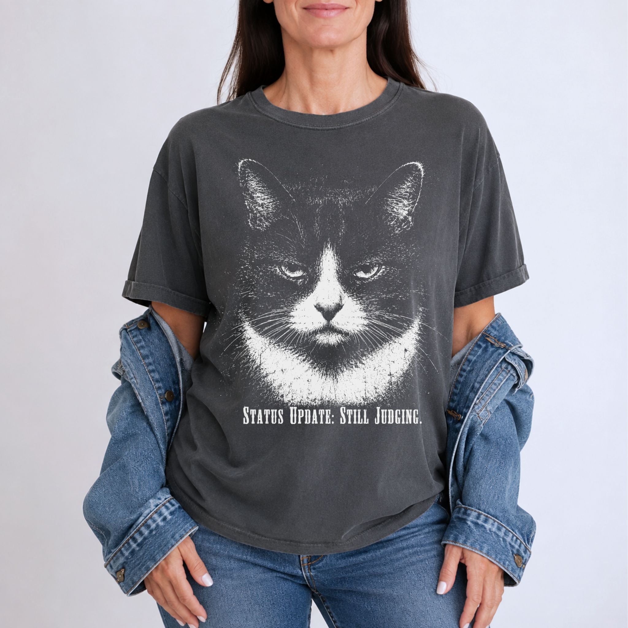 Woman wearing a Pepper Still Judging t-shirt with a large tuxedo cat graphic