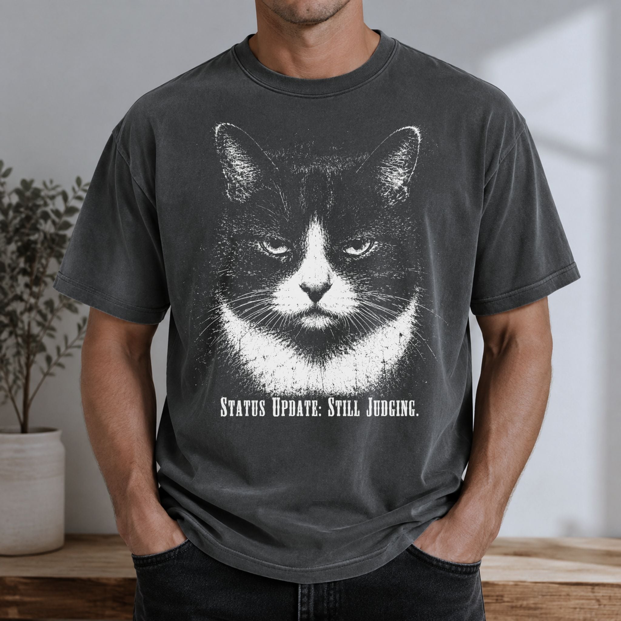 Man wearing a Pepper Still Judging t-shirt with a large tuxedo cat graphic