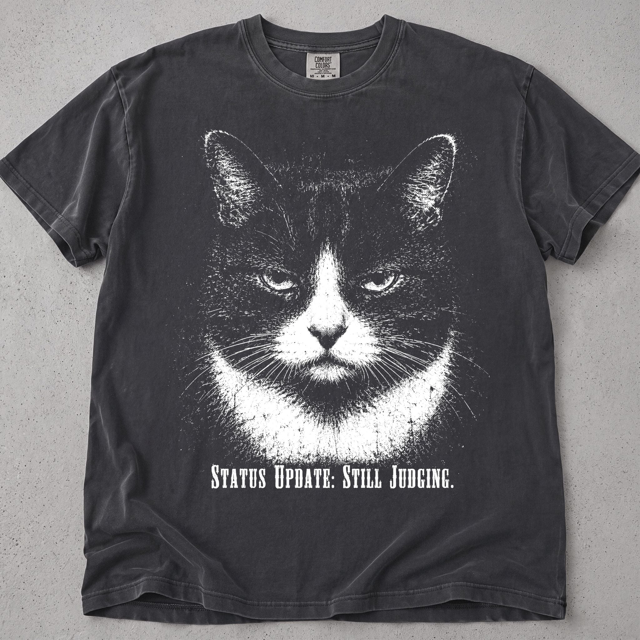 Pepper Still Judging cat t-shirt with black and white tuxedo cat graphic, front flat lay
