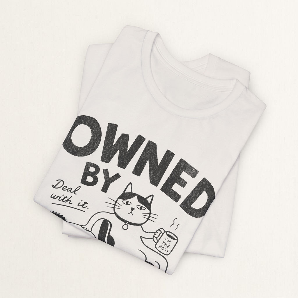 Folded vintage white Owned By My Cat t-shirt with comic cat boss graphic