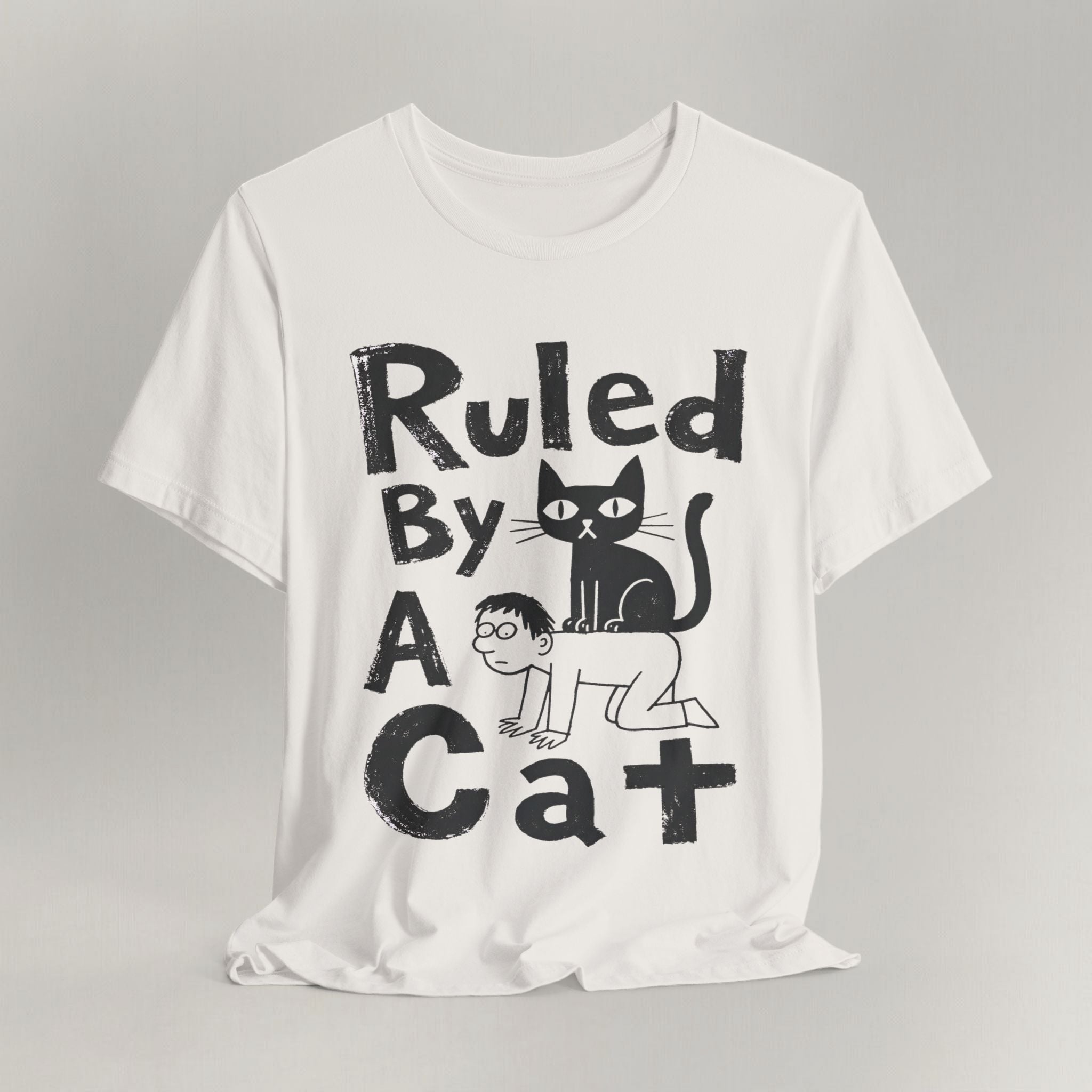Flat lay of vintage white graphic cat t-shirt with Ruled By A Cat print design