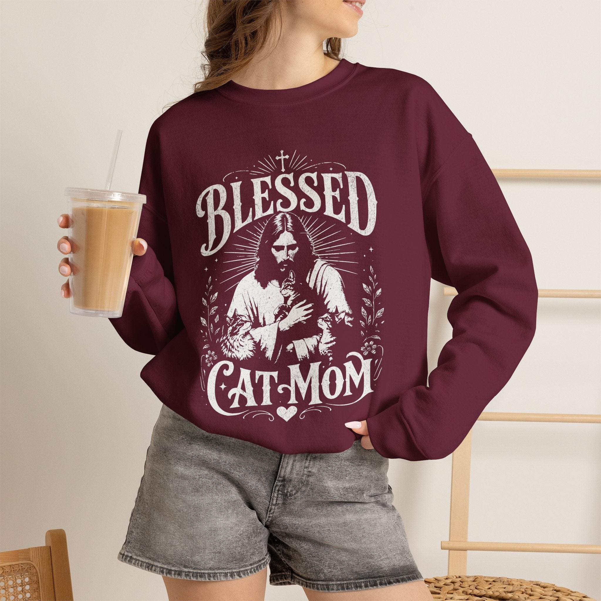 Woman wearing a maroon Blessed Cat Mom printed cat sweatshirt
