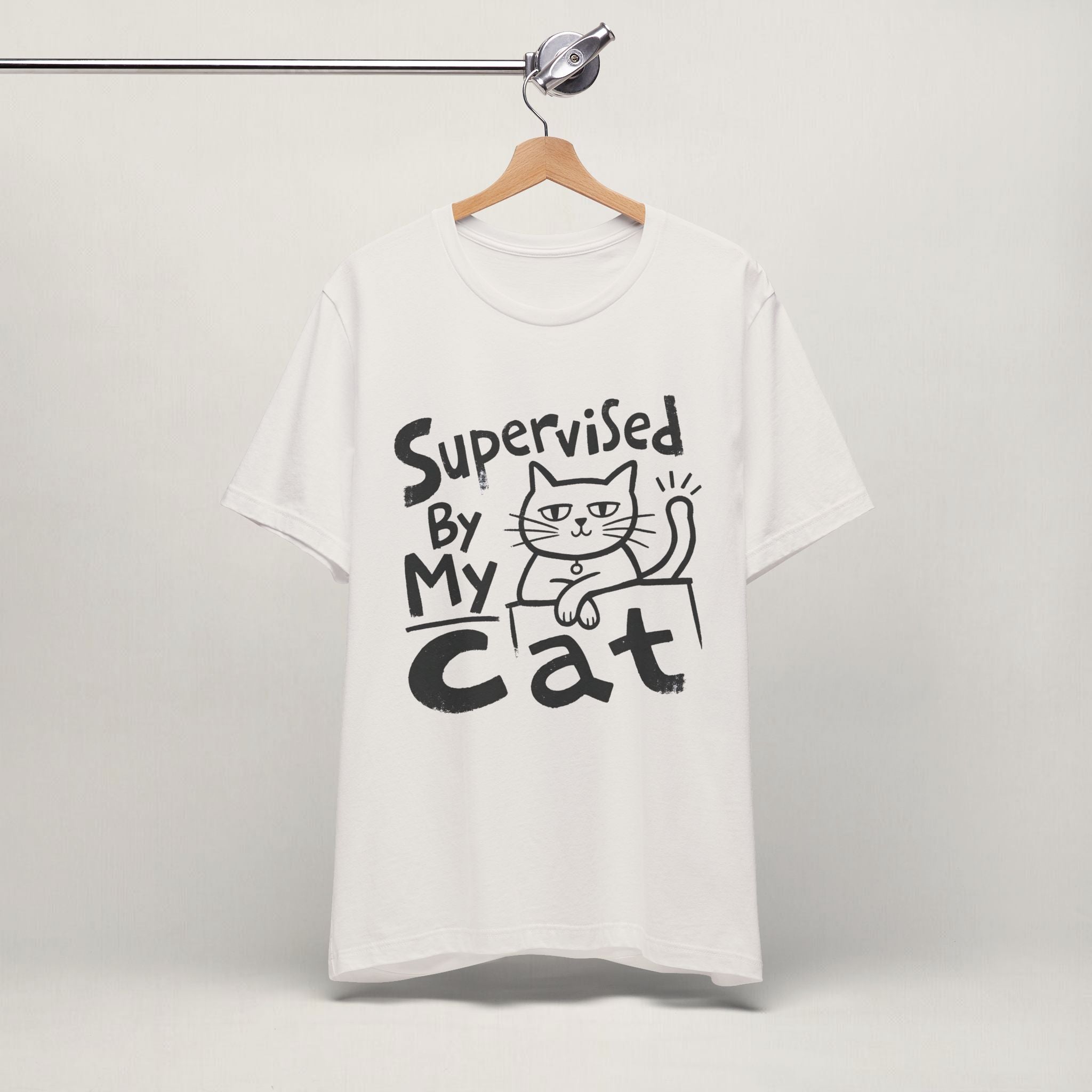 Vintage white Supervised By My Cat t-shirt with hand-drawn graphic hanging on display