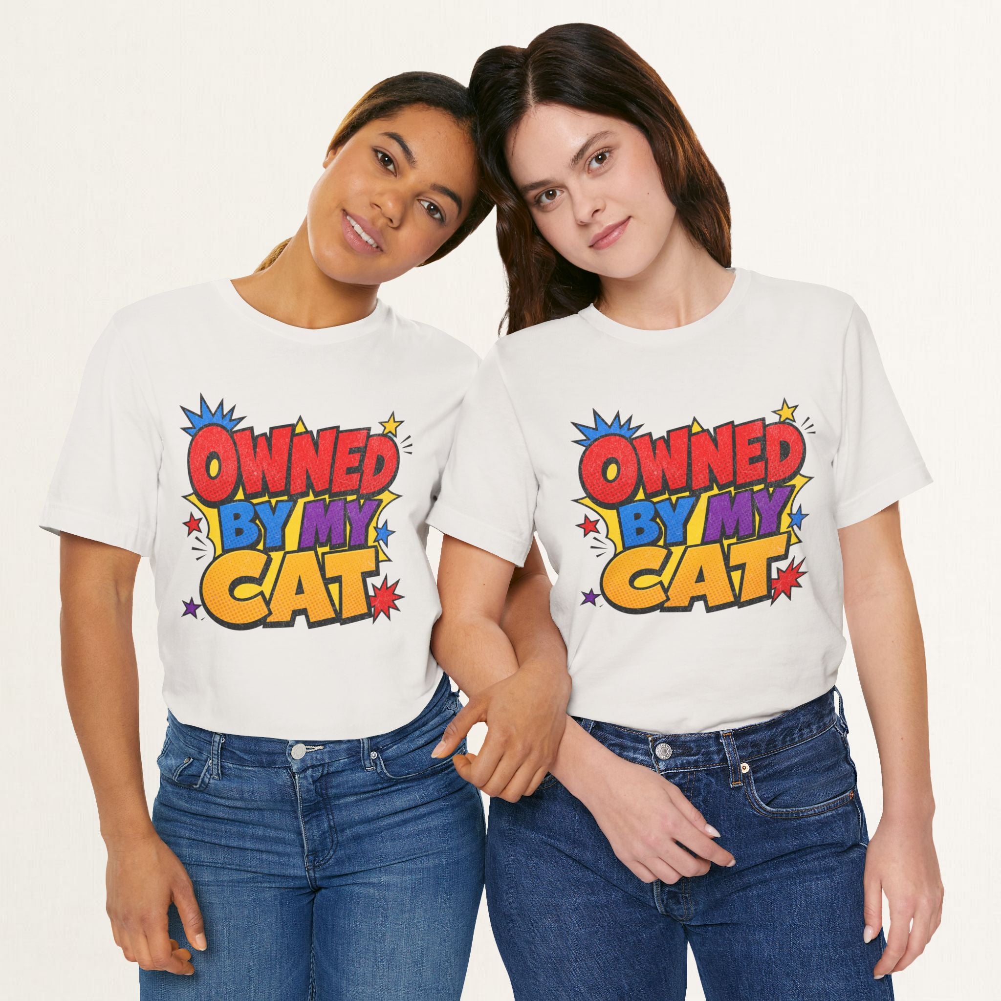 Two women wearing vintage white Owned By My Cat t-shirts with colorful comic graphic