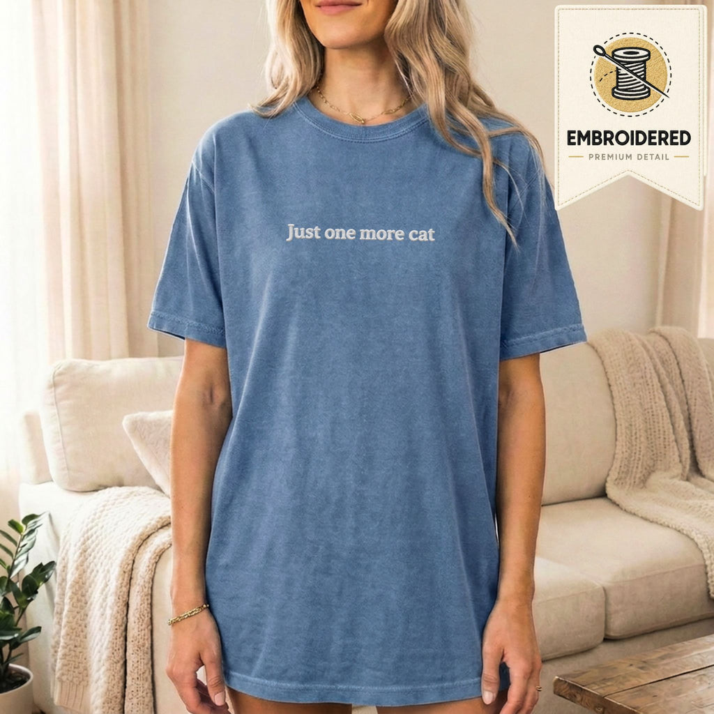 Woman wearing a blue jean embroidered 'Just One More Cat' t-shirt