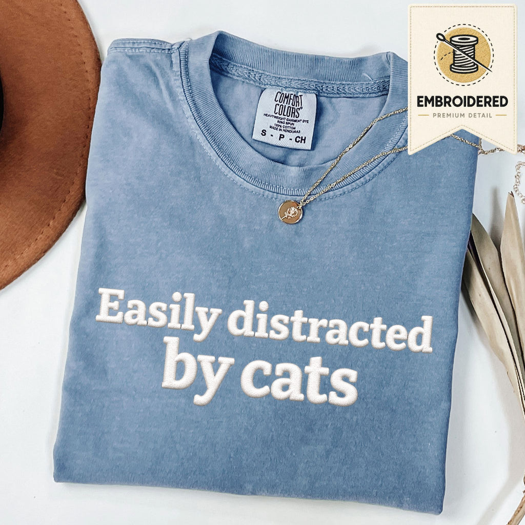 Blue Jean embroidered cat t-shirt with 'Easily Distracted' chest design, shown flat