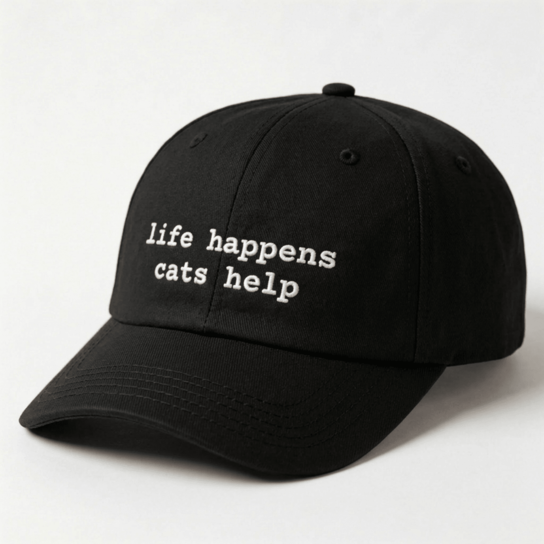 Black cap with 'life happens cats help' text on a white background