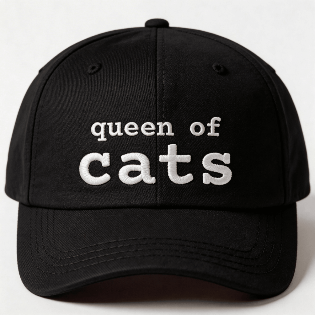 Black embroidered cat cap with the phrase “queen of cats” shown from the front