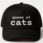 Black embroidered cat cap with the phrase “queen of cats” shown from the front