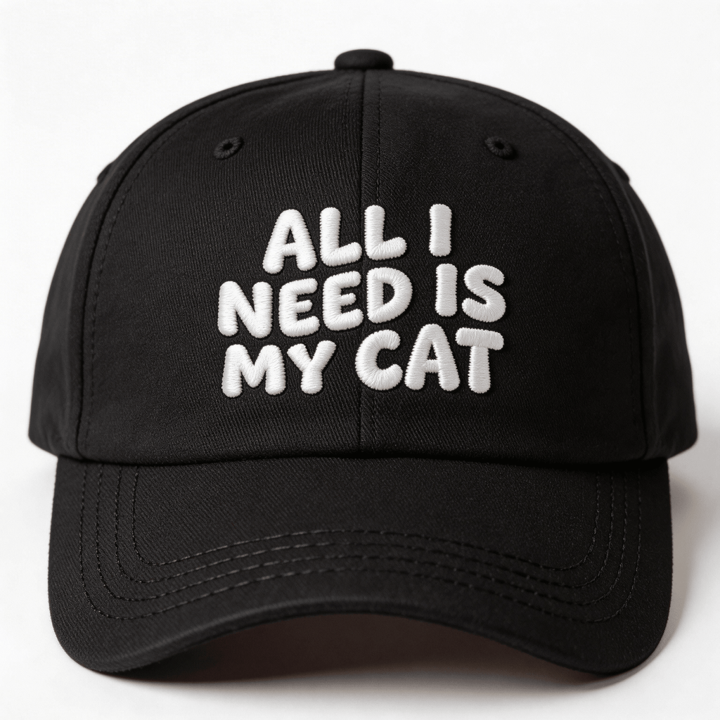 Black embroidered cap with white text that says “All I Need Is My Cat” shown from the front