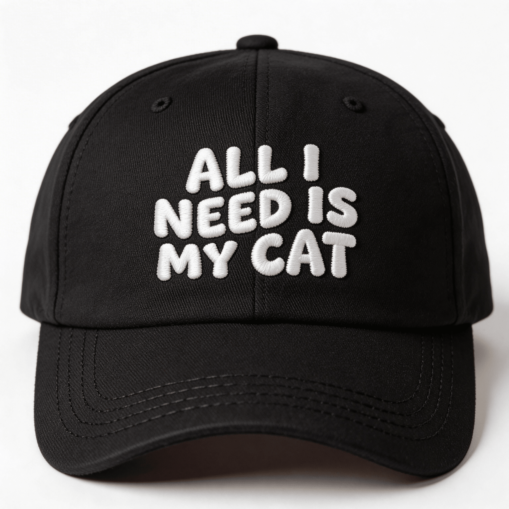 Black embroidered cap with white text that says “All I Need Is My Cat” shown from the front