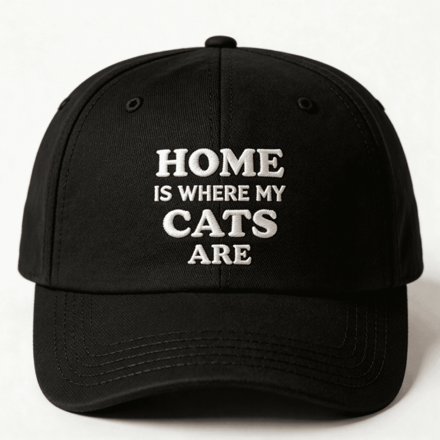 Black cap with white text that says “Home Is Where My Cats Are” shown from the front