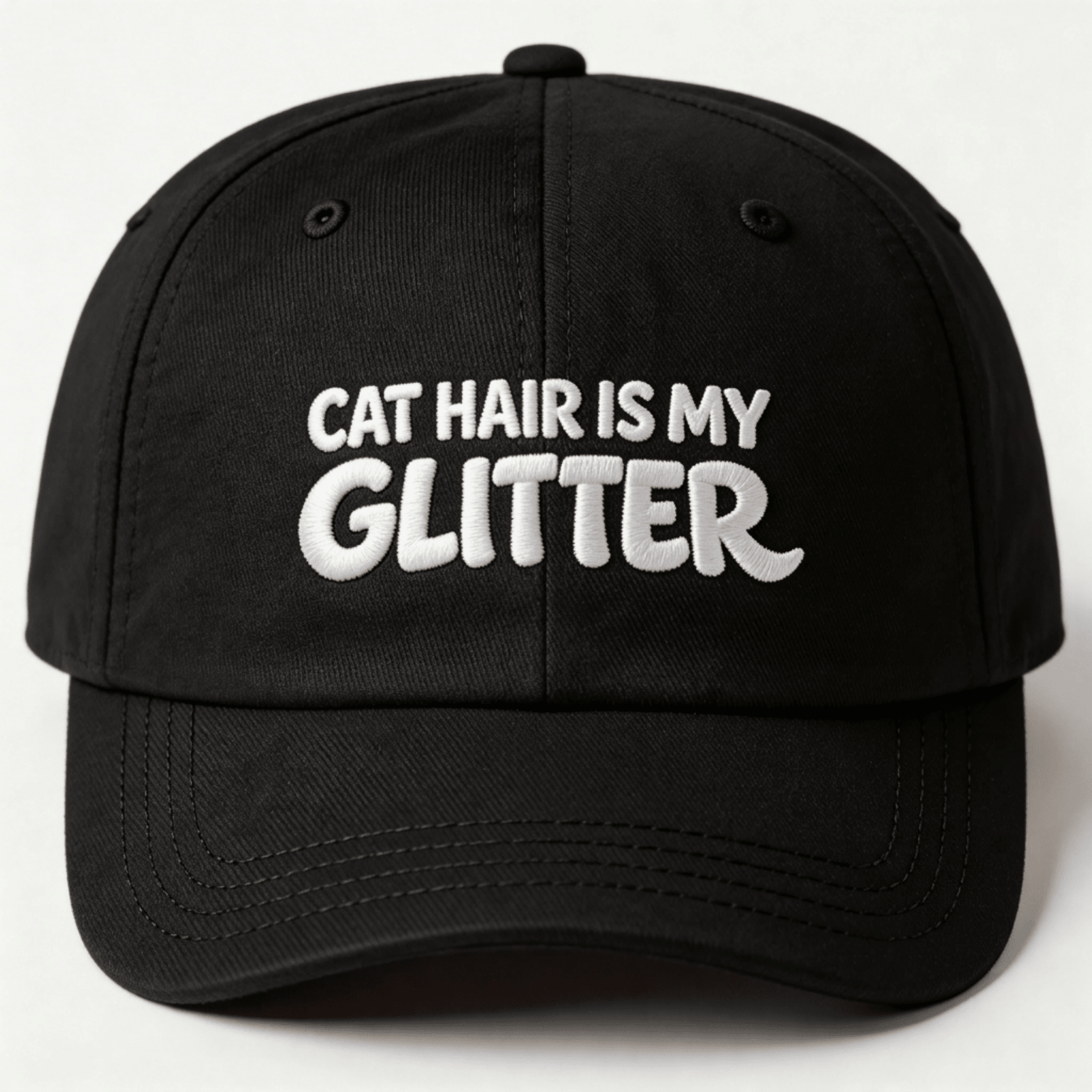 Front view of a black embroidered classic dad cap with white text that says "CAT HAIR IS MY GLITTER"