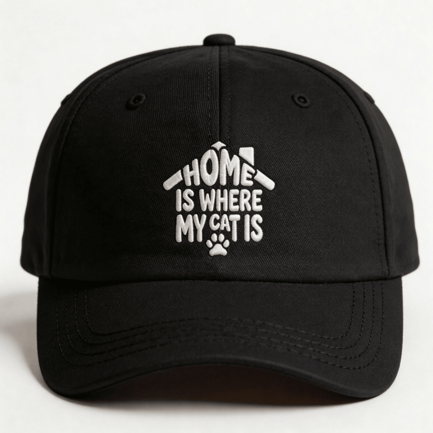 Black embroidered cap with white text that says “Home Is Where My Cat Is” shown from the front