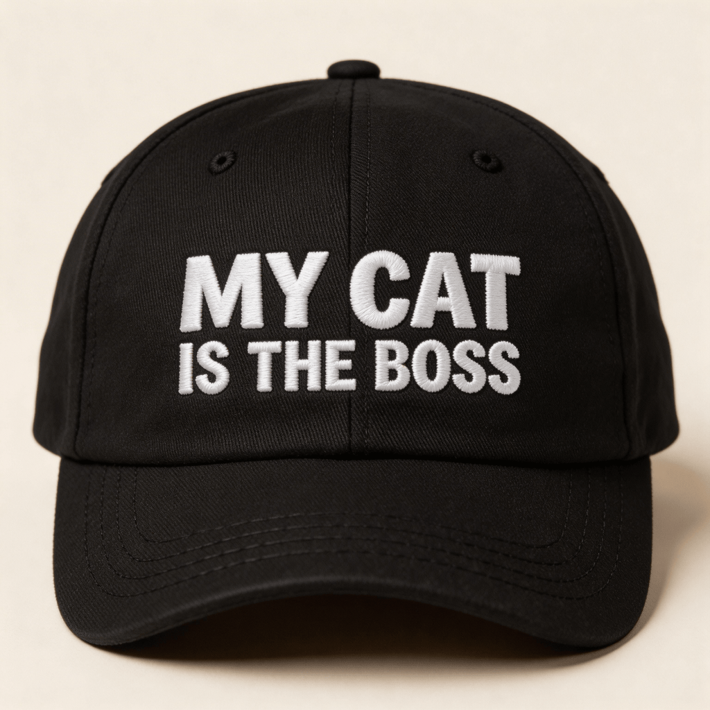 Front view of a black embroidered baseball cap with white text that says "MY CAT IS THE BOSS"