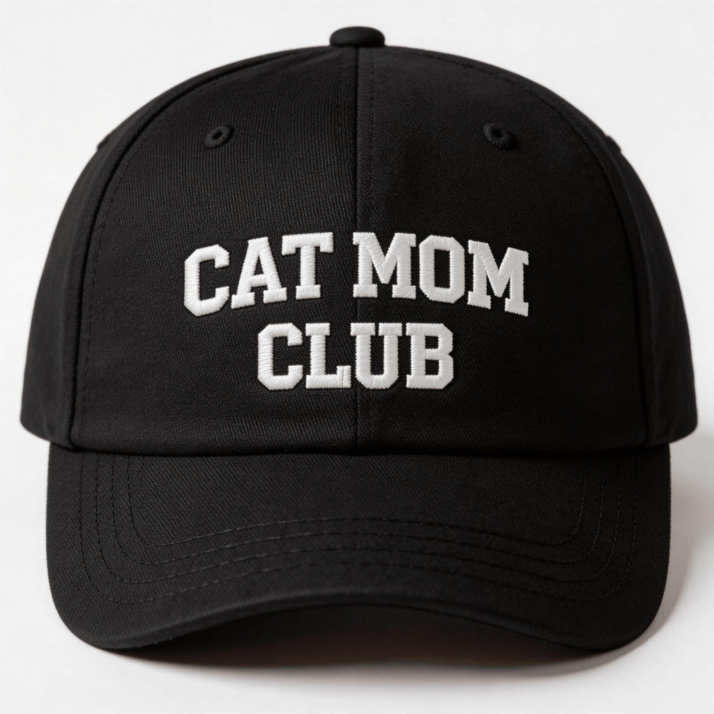 Black embroidered cap with white text that says “Cat Mom Club” shown from the front