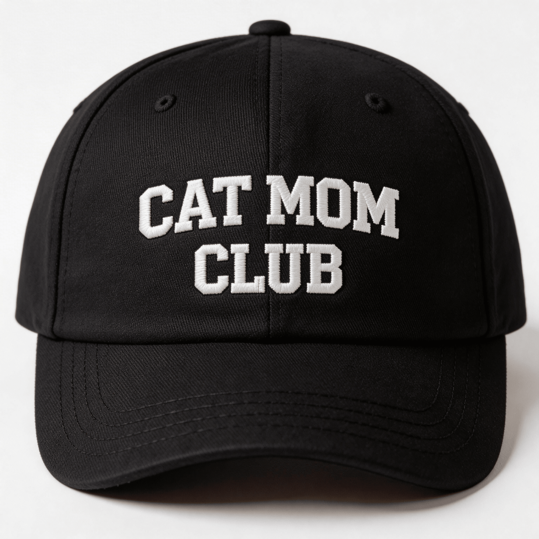 Black embroidered cap with white text that says “Cat Mom Club” shown from the front